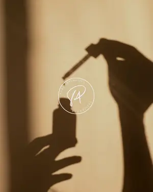 Shadow of a hand holding a dropper bottle beside the Pure Aesthetics logo